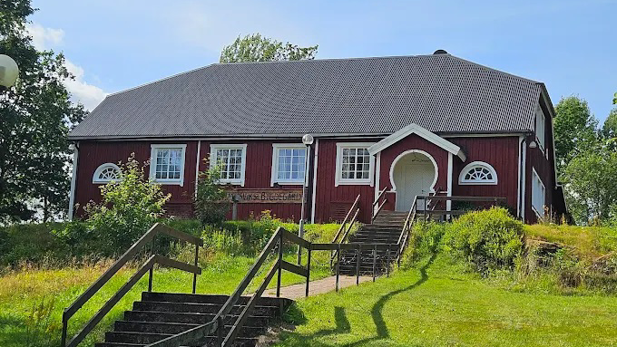 Ett rödmålat hus med grått tak och texten bygdegård på fasaden