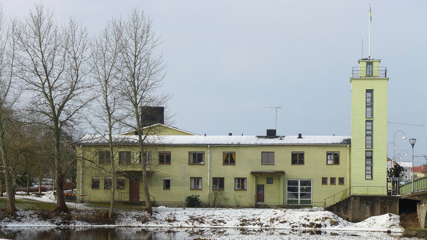 Ett stort gulmålat hus med torn i ena hörnet