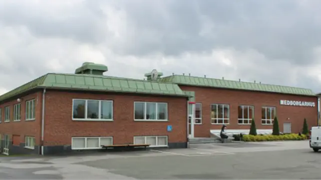 Låg tegelbyggnad med grönt tak och texten medborgarhus på fasaden