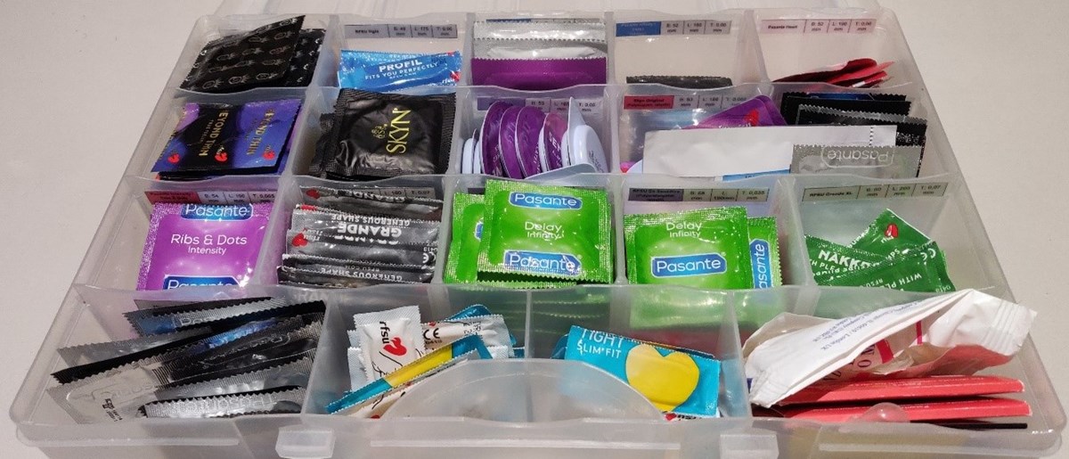 Låda med fack fyllda med olika sorters kondomer