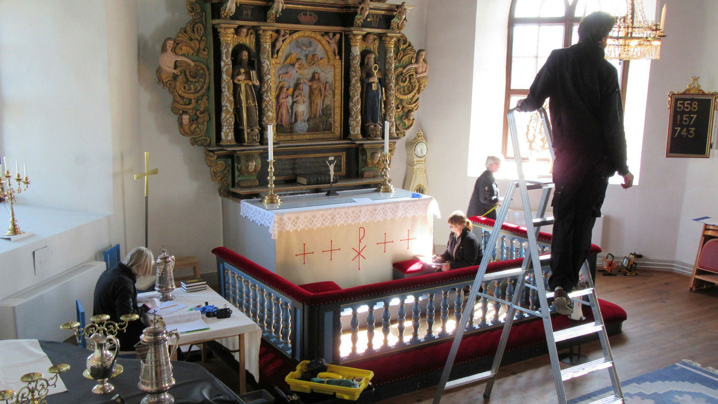 Konservatorer arbetar med inventering och katalogisering i en kyrka.