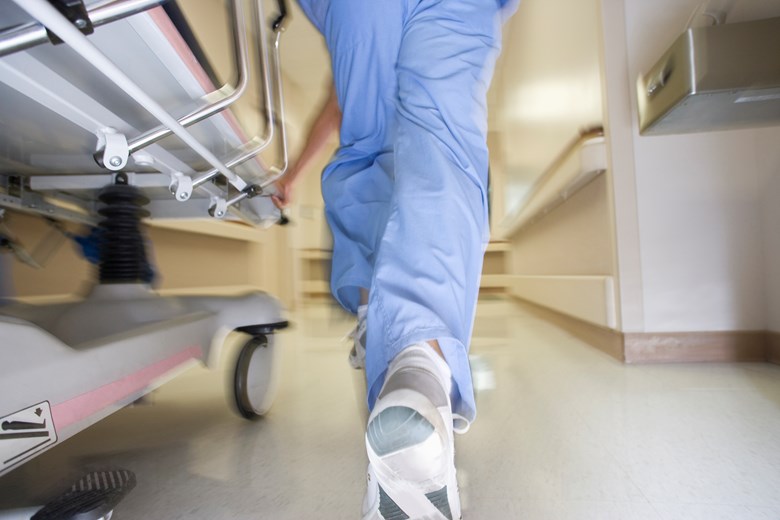 Sjukvårdare springer i korridor med en säng