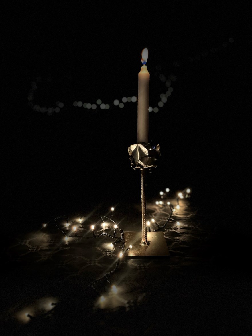 Ett levande ljus står på ett bord med ljusslinga