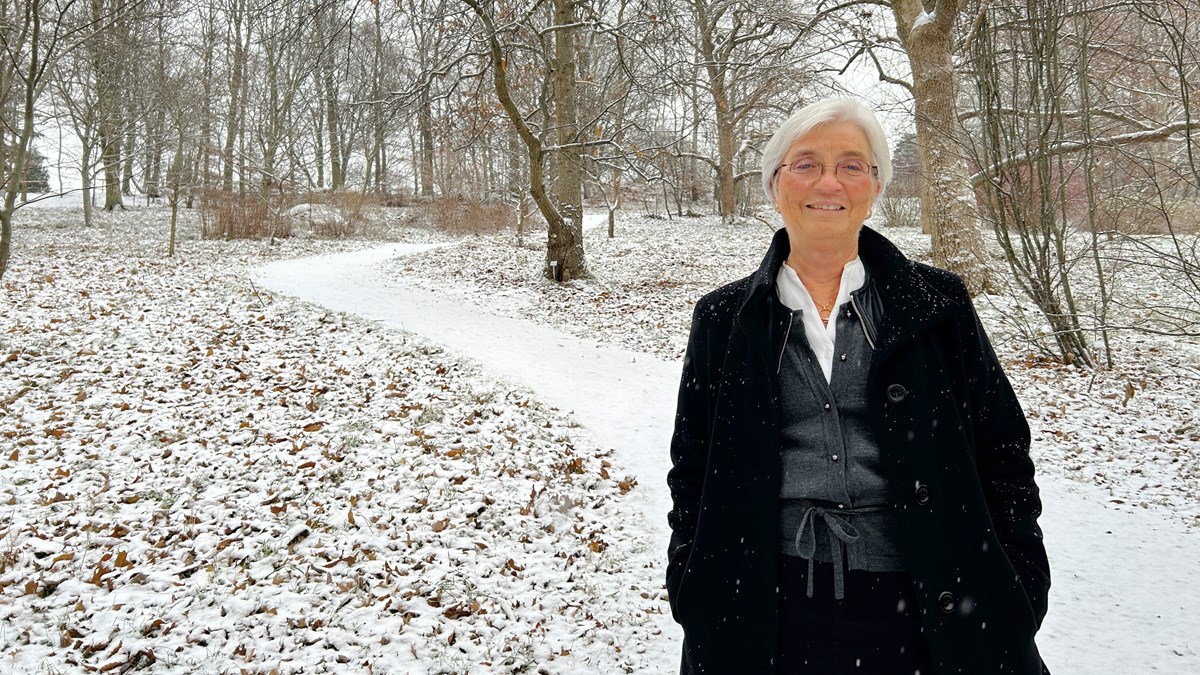 Kvinna går på slingrande väg i snölandskap