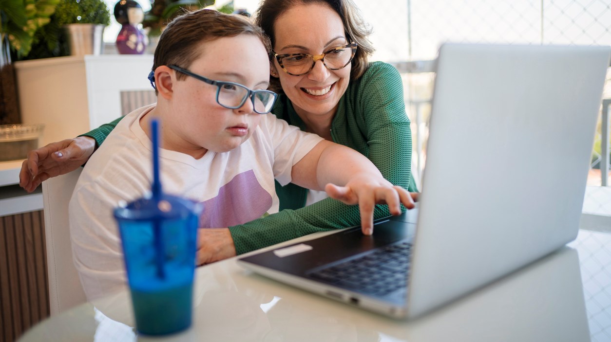 Mor och son gör skoluppgift vid laptop