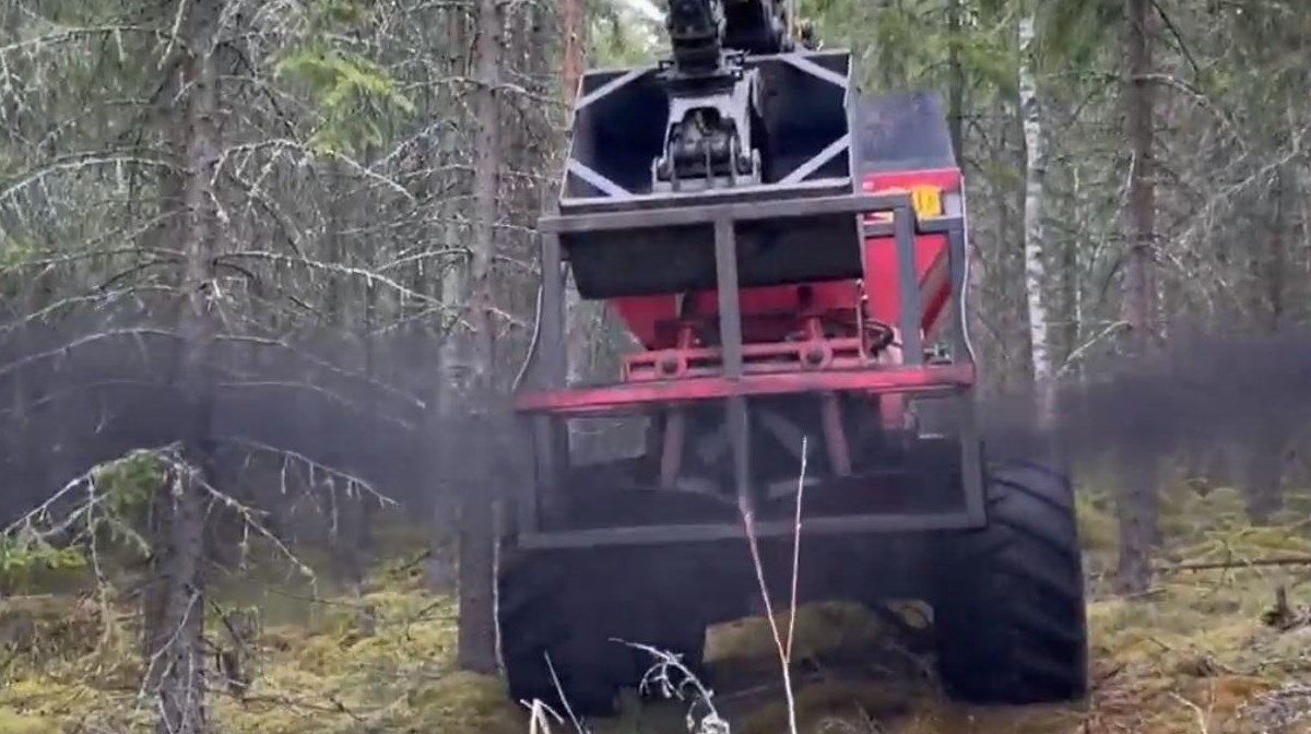 En skogsmaskin sprider ut aska i skogen