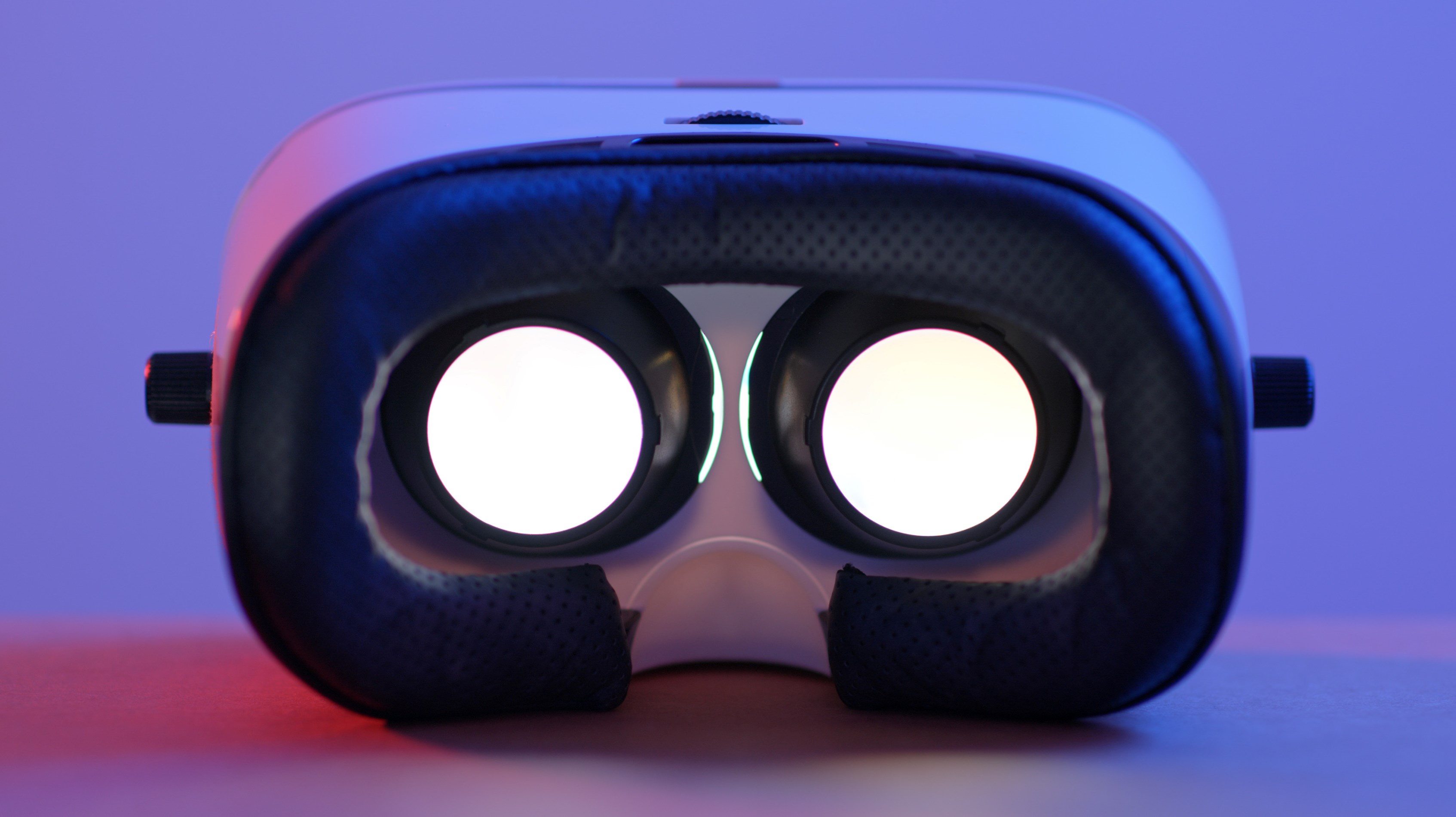 lila bakgrund, ett par glasögon som ser ut som kraftigare skidglasögon. Svart mjukt skydd, två vita hål där ögonen ska placeras