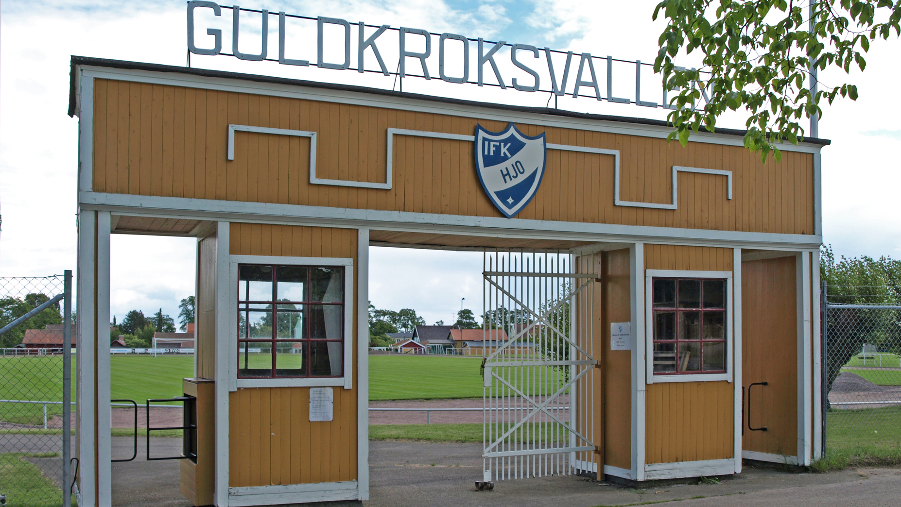 entré till idrottsområde i trä med detaljer i vitt