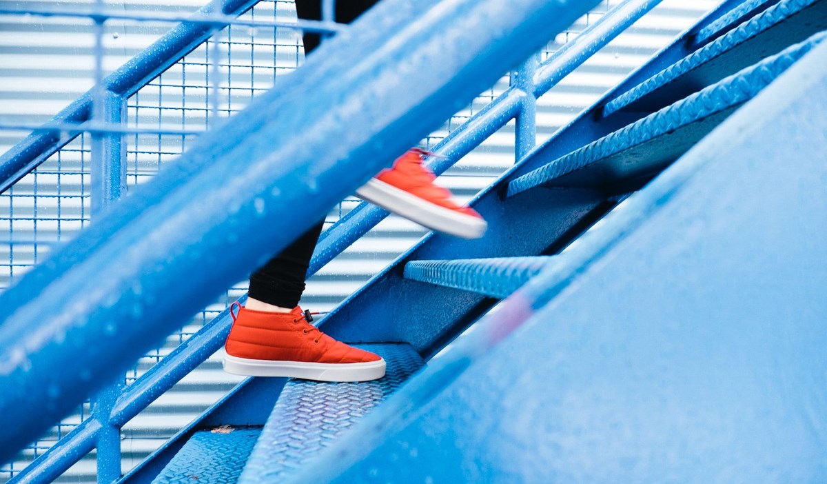 Person i röda skor går uppför en blå trappa