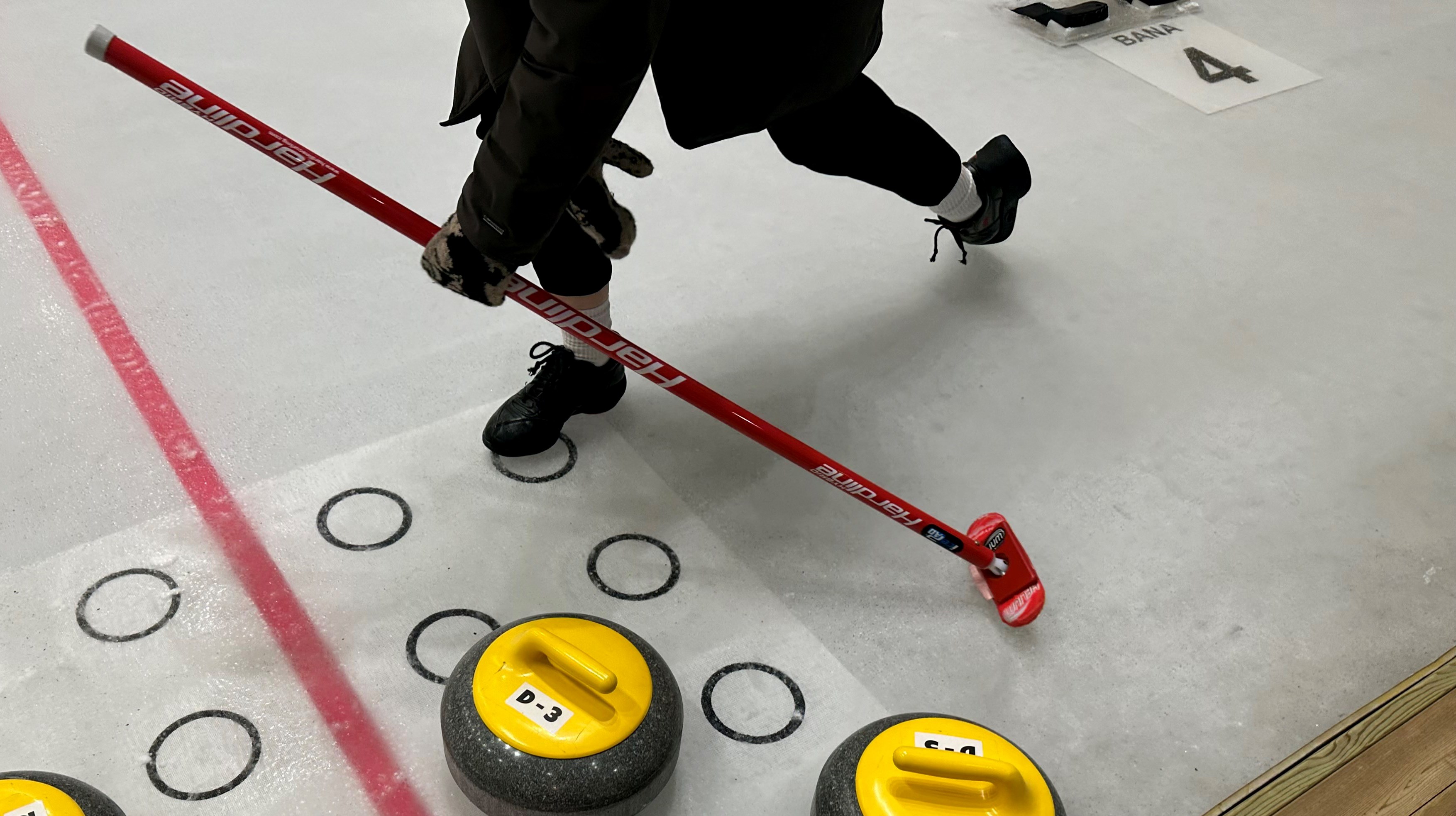 En person på en curlingbana.