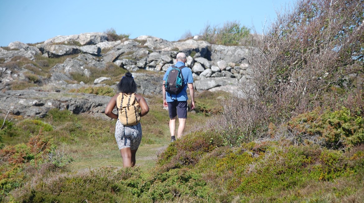 Två personer går med ryggsäckar på en vandringsled