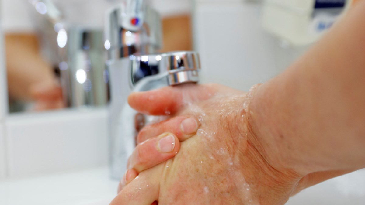 Närbild på vattenkran och händer som tvättas
