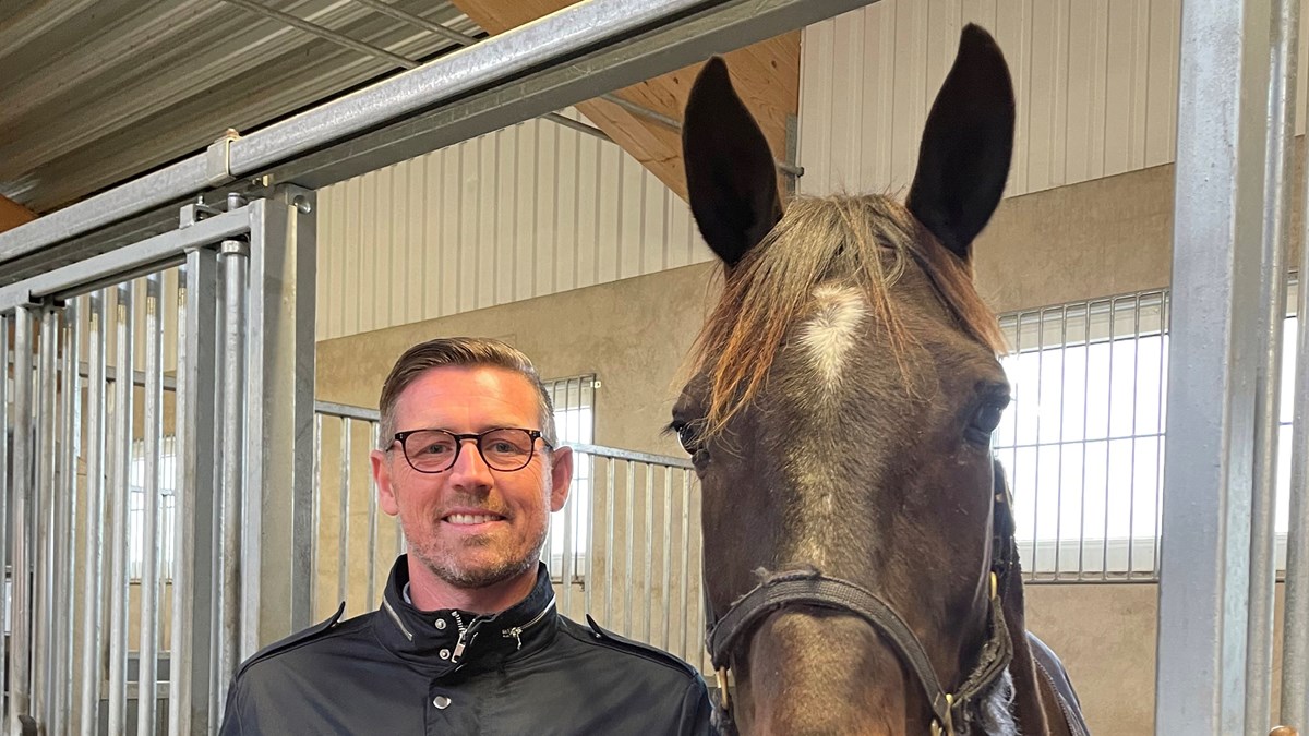Porträtt på rektor Niclas Dahlqvist bredvid en häst