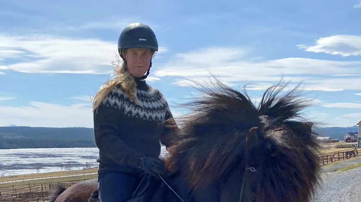 Porträttbild av Malin Jansson i ridhjälm på islandshäst