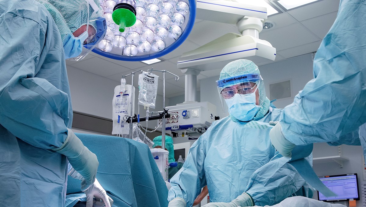 Kirurger opererar en patient i en operationssal.