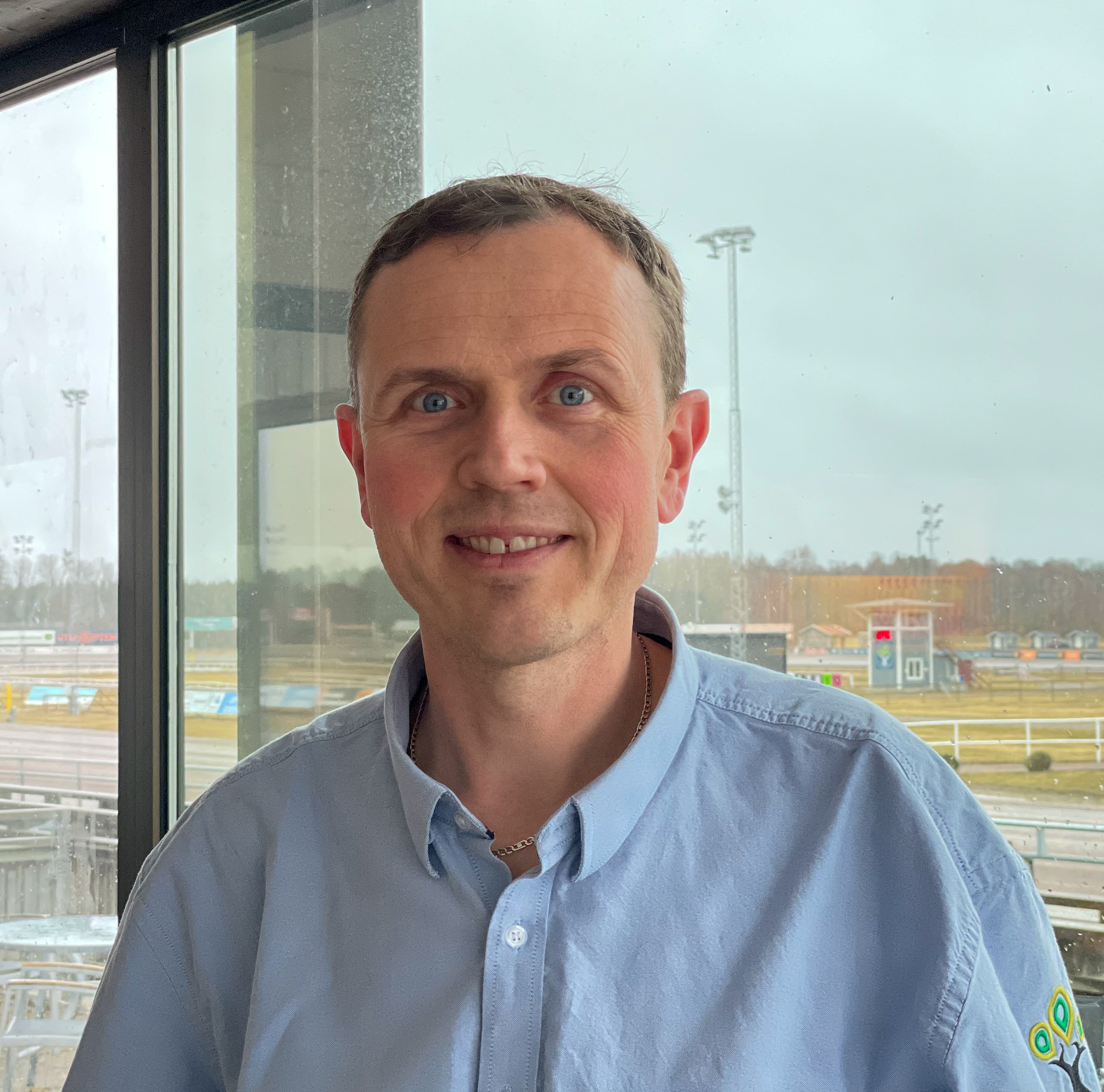 Foto på Kent Karlsson med Axevalla travbana i bakgrunden