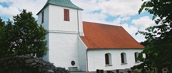 En vit kyrka med rött tak och ett spetsigt kyrktorn