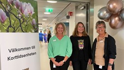 Tre leende kvinnor vid skylt som säger: Välkommen till Korttidsenheten, Kungälvs kommun.