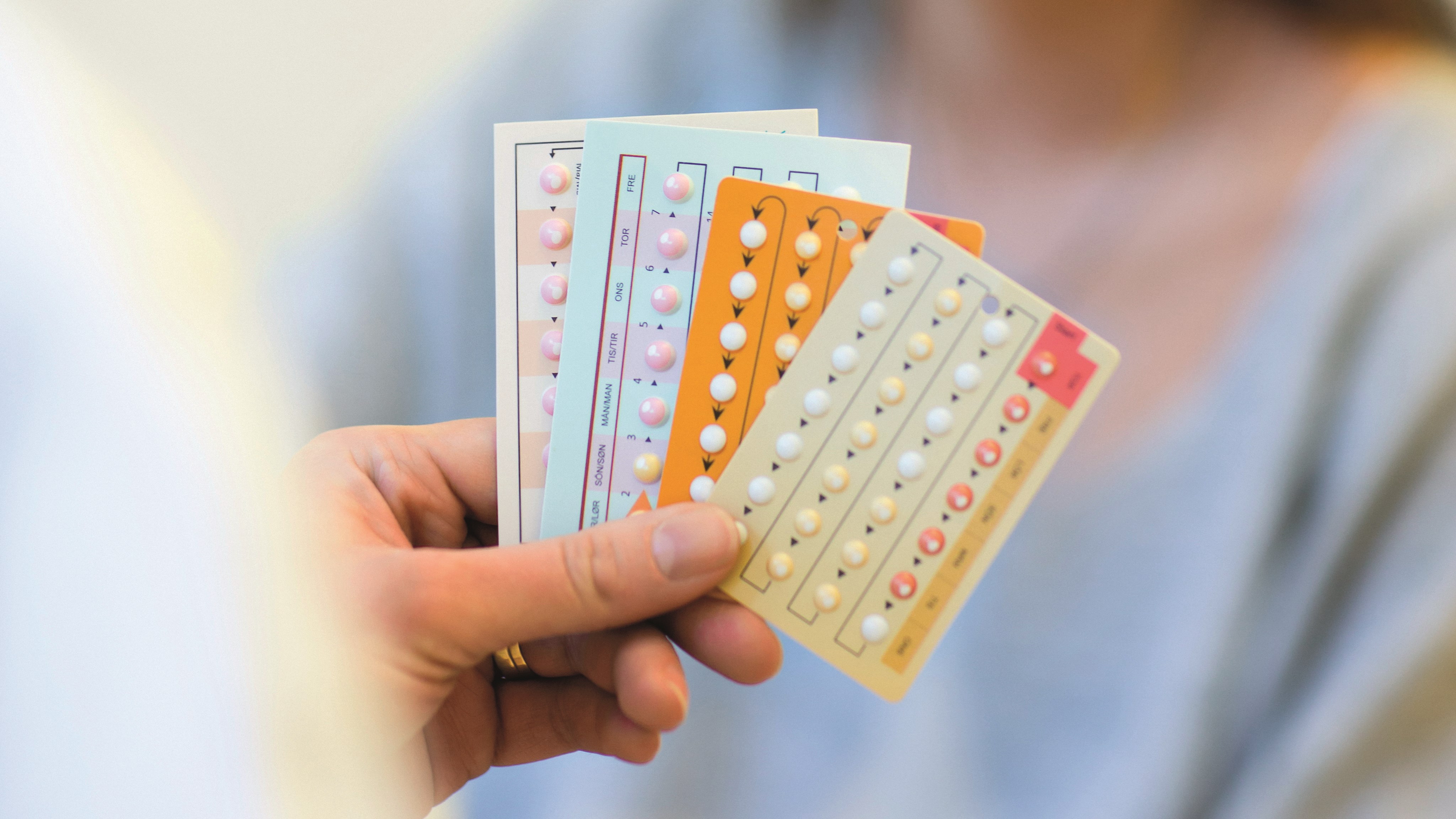 Hand håller kartor med p-piller, preventivmedel