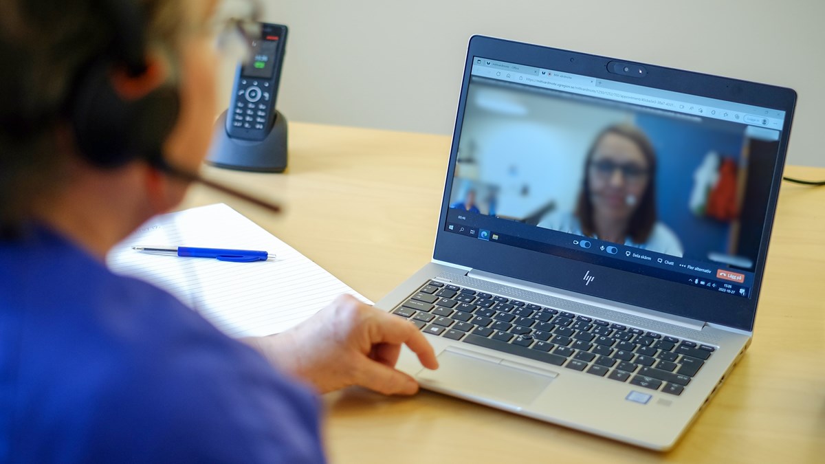 Vårdpersonal har ett digitalt möte med en patient via en dator.