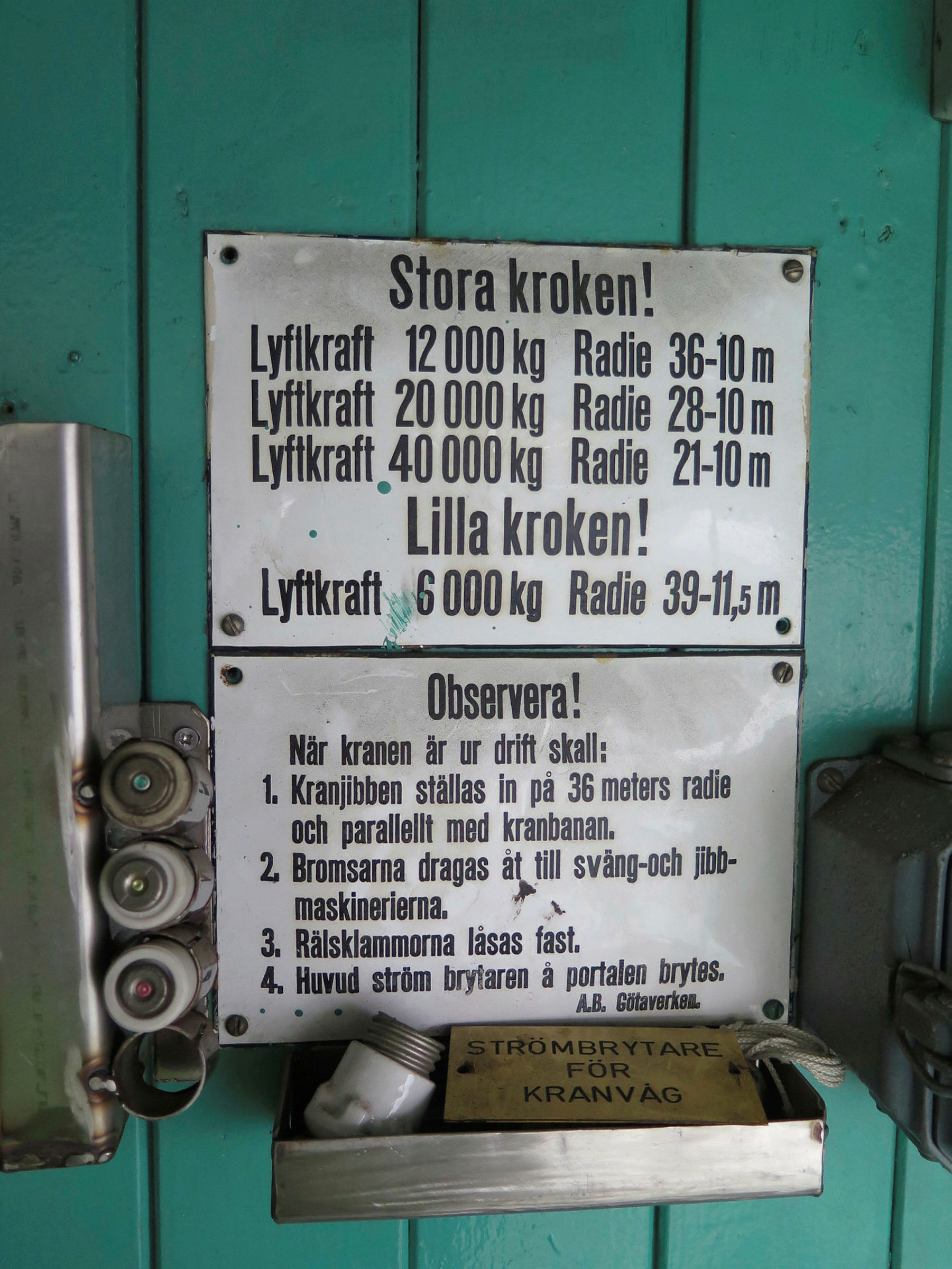 Skylt med viktangivelser och radie för stora och lilla kroken. Varningsskylt: När kranen är i drift skall 1. Kranjobben ställas in på 36 meters radie och parallellt med kranbanan. 2. Bromsarna dragas åt till sväng och jibb-maskinerna. 3. Rälsklammerna låsas fast. 4. Huvud ström brytaren à portalen brytes.