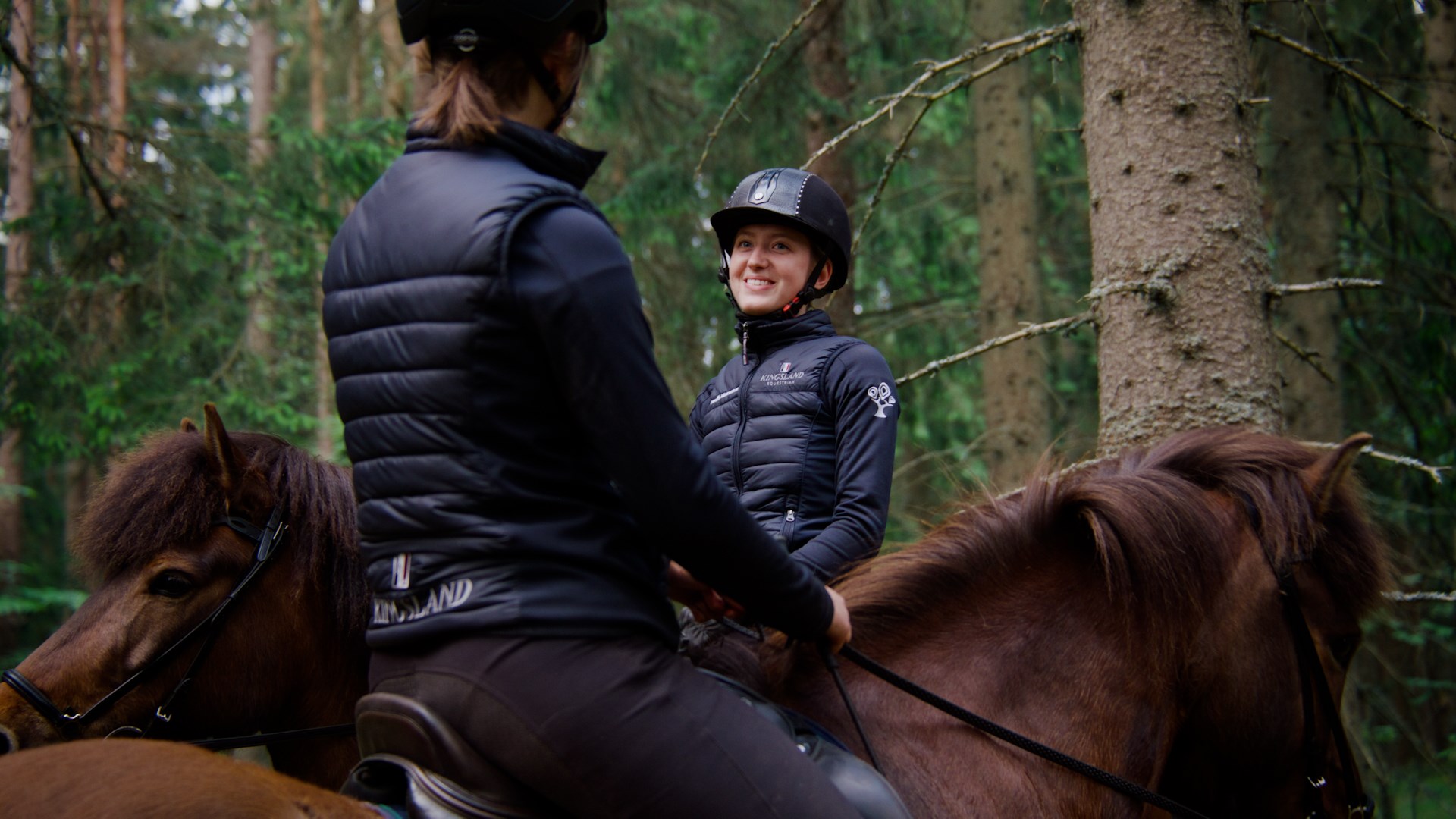 Två elever med hästar i skogsmiljö