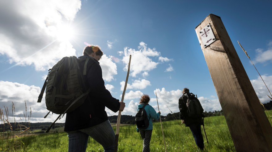 Tre personer vandrar som pilgrimer