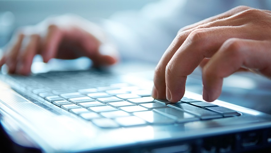 Händer skriver på ett tangentbord.