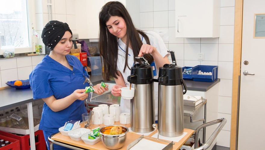 Två unga kvinnor som fixar fika