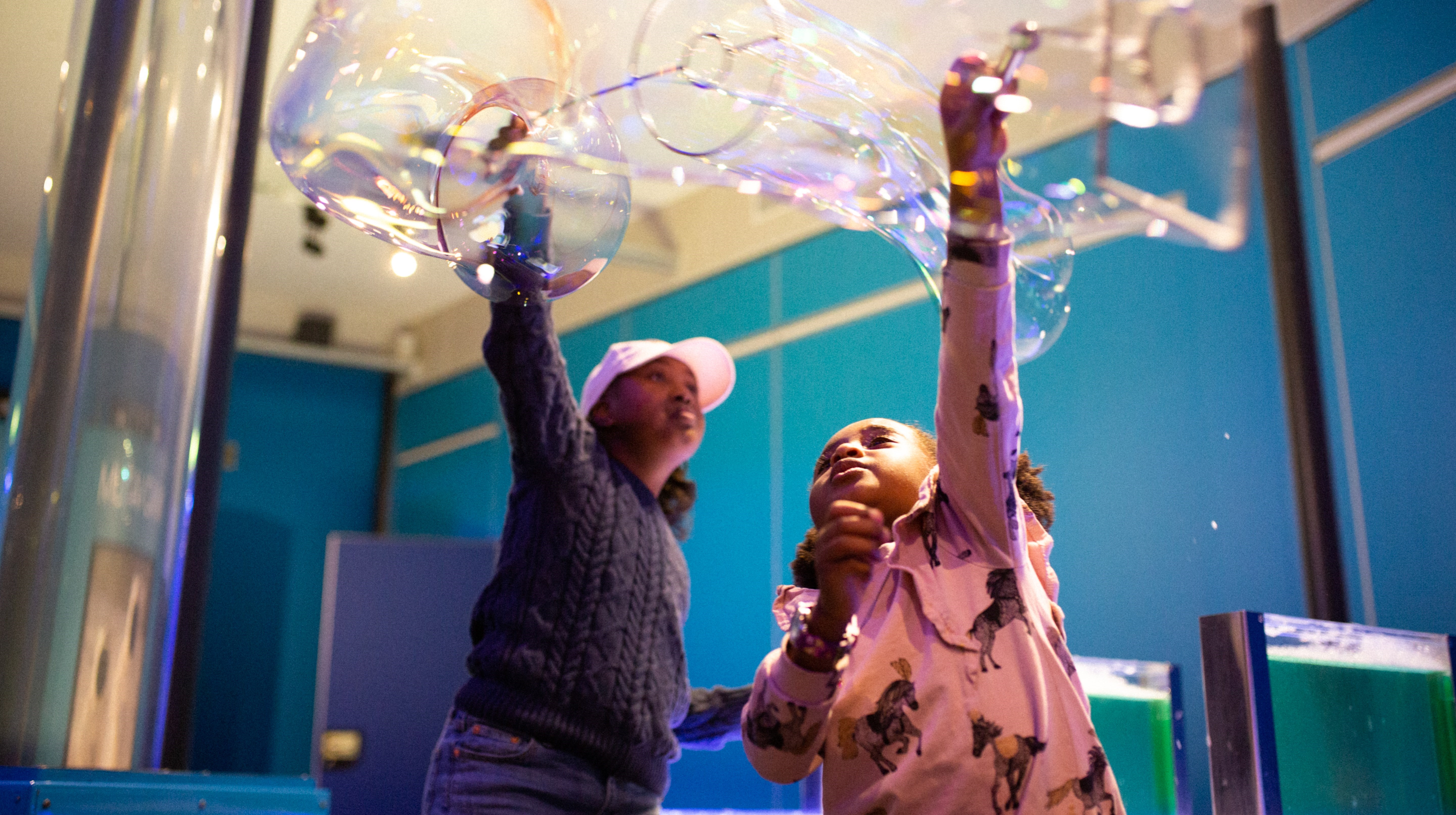Två barn som leker med gigantiska såpbubblor.