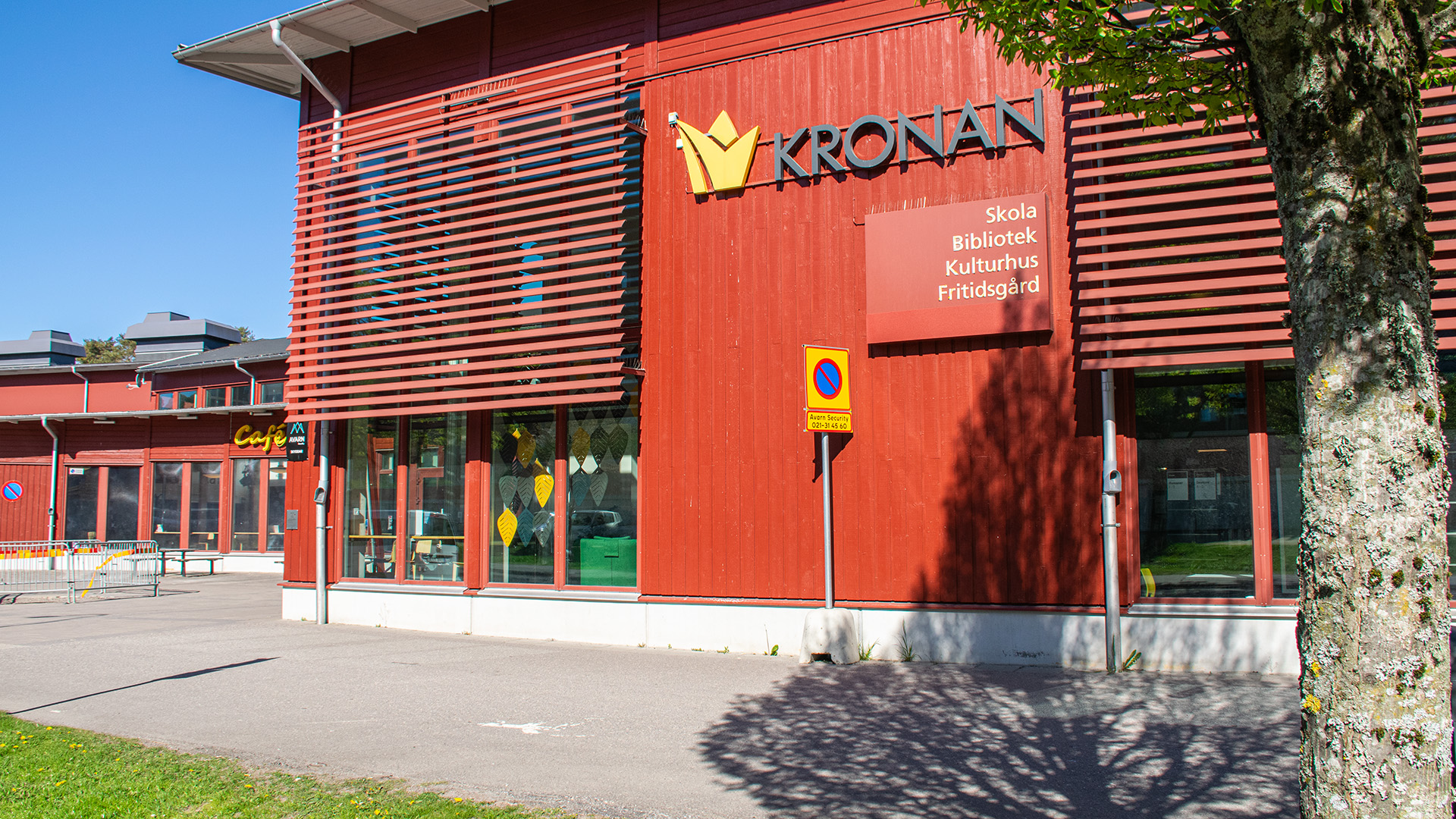 Kronan Kulturhus. En röd byggnad i trä. På utsidan av huset står det KRONAN och Skola, Bibliotek, Kulturhus och Fritidsgård.