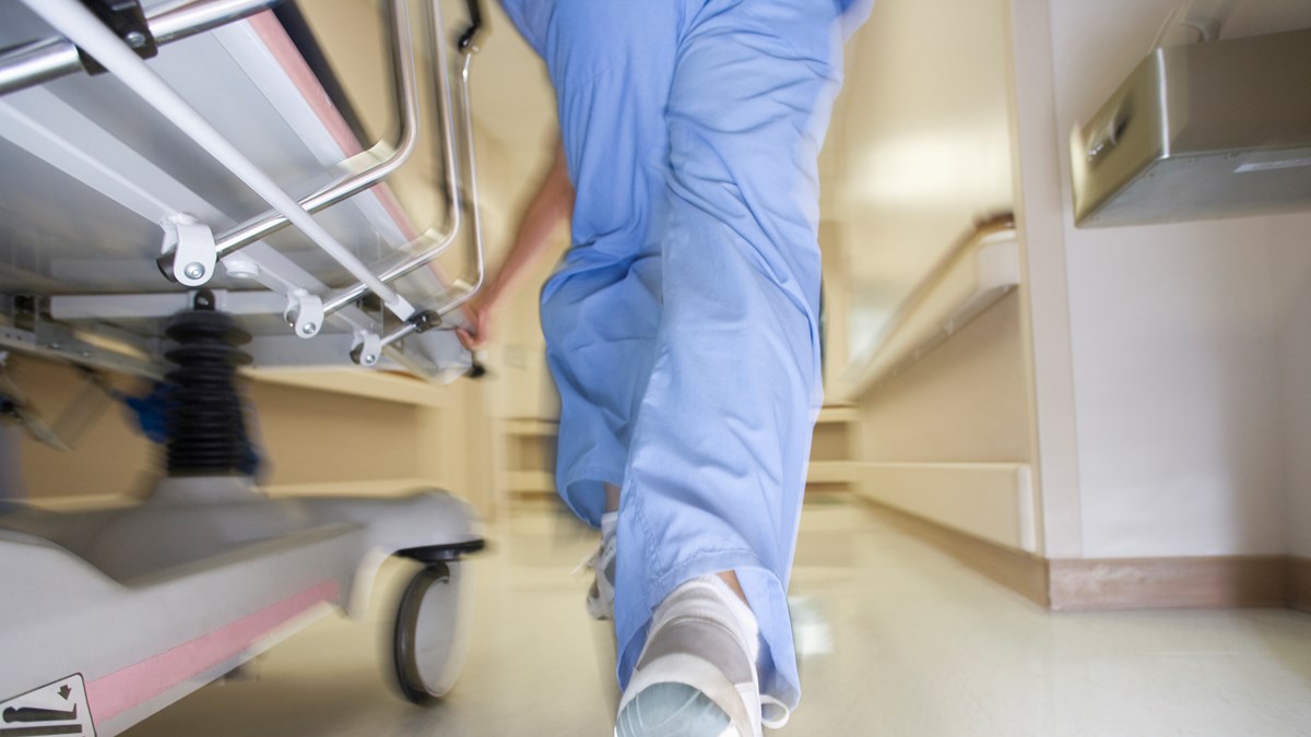 Sjukvårdare springer i korridor med en säng