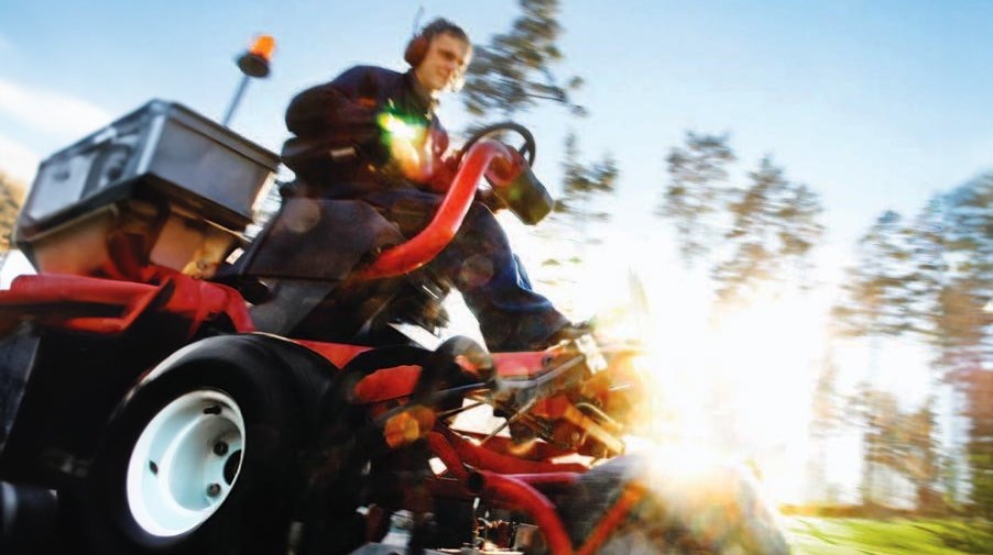 Förare med stor maskin och solsken i bakgrunden