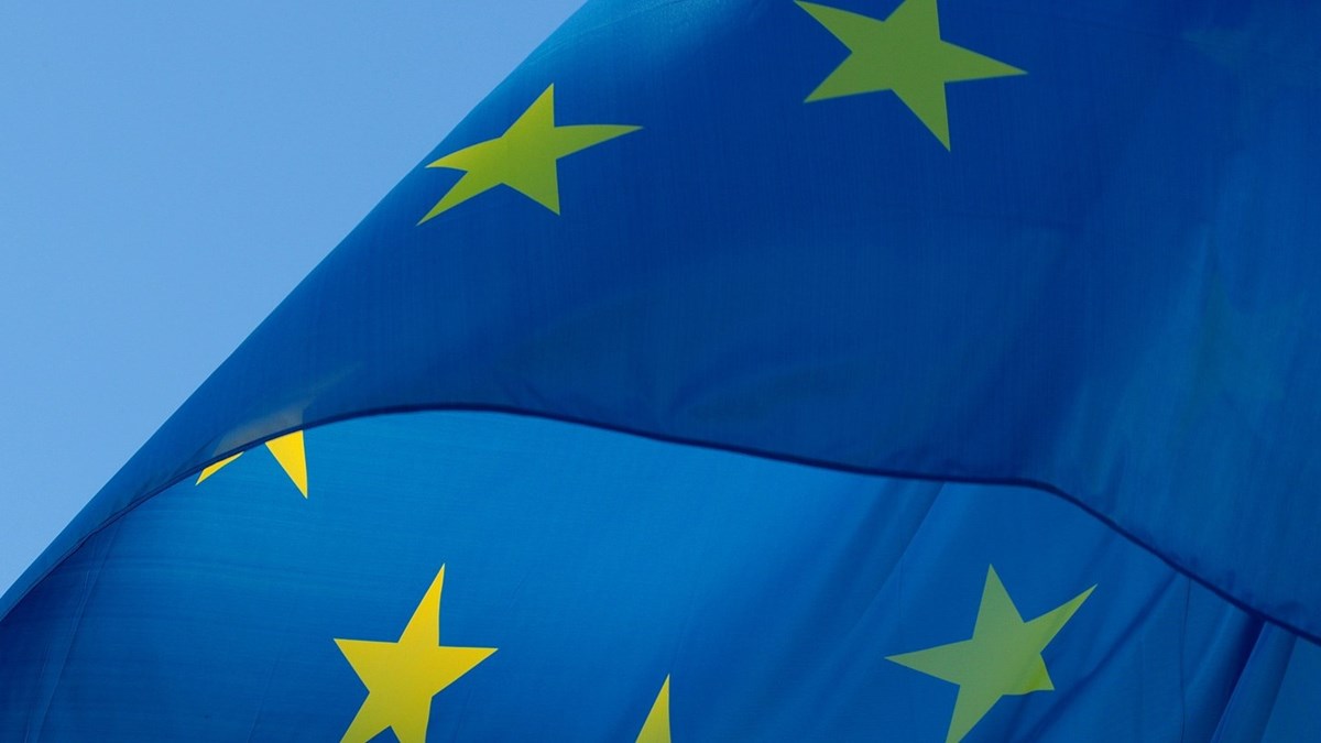 Den blåa Europeiska flaggan vajar i vinden, solen lyser på dom gula stjärnorna.