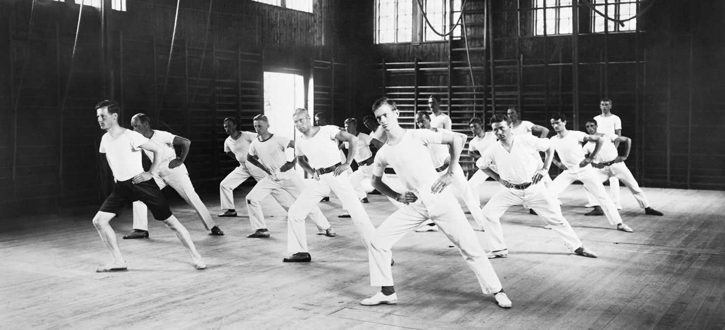 En grupp män gymnastiserar i Källnääs gymnastiksal omkring 1930-talet