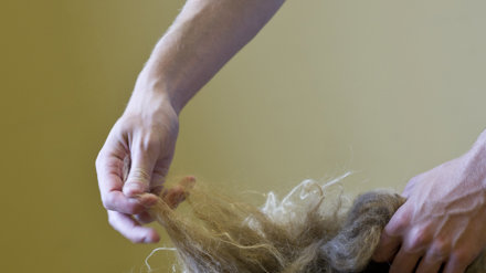 Händer som arbetar med att tova ull