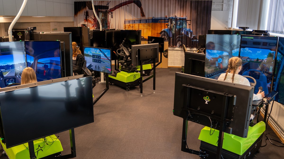 Elever sitter i simulatorer med skärmar och kör olika slags maskiner