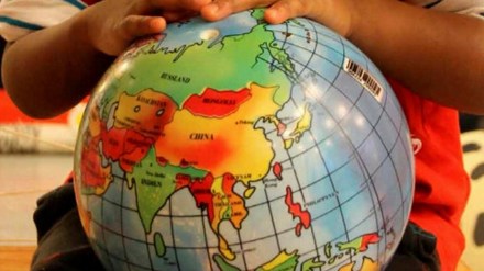 Framsida på en rapport där ett barn håller en jordglob