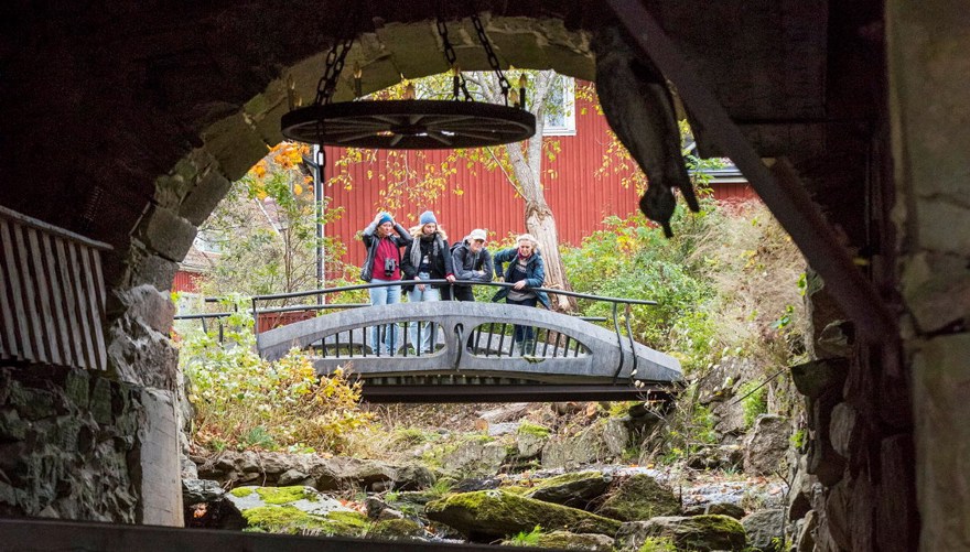 Fyra personer på en bro vid en fors