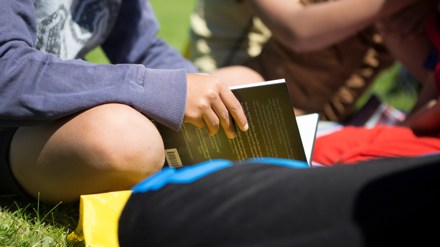 Barnhänder som håller i en bok.