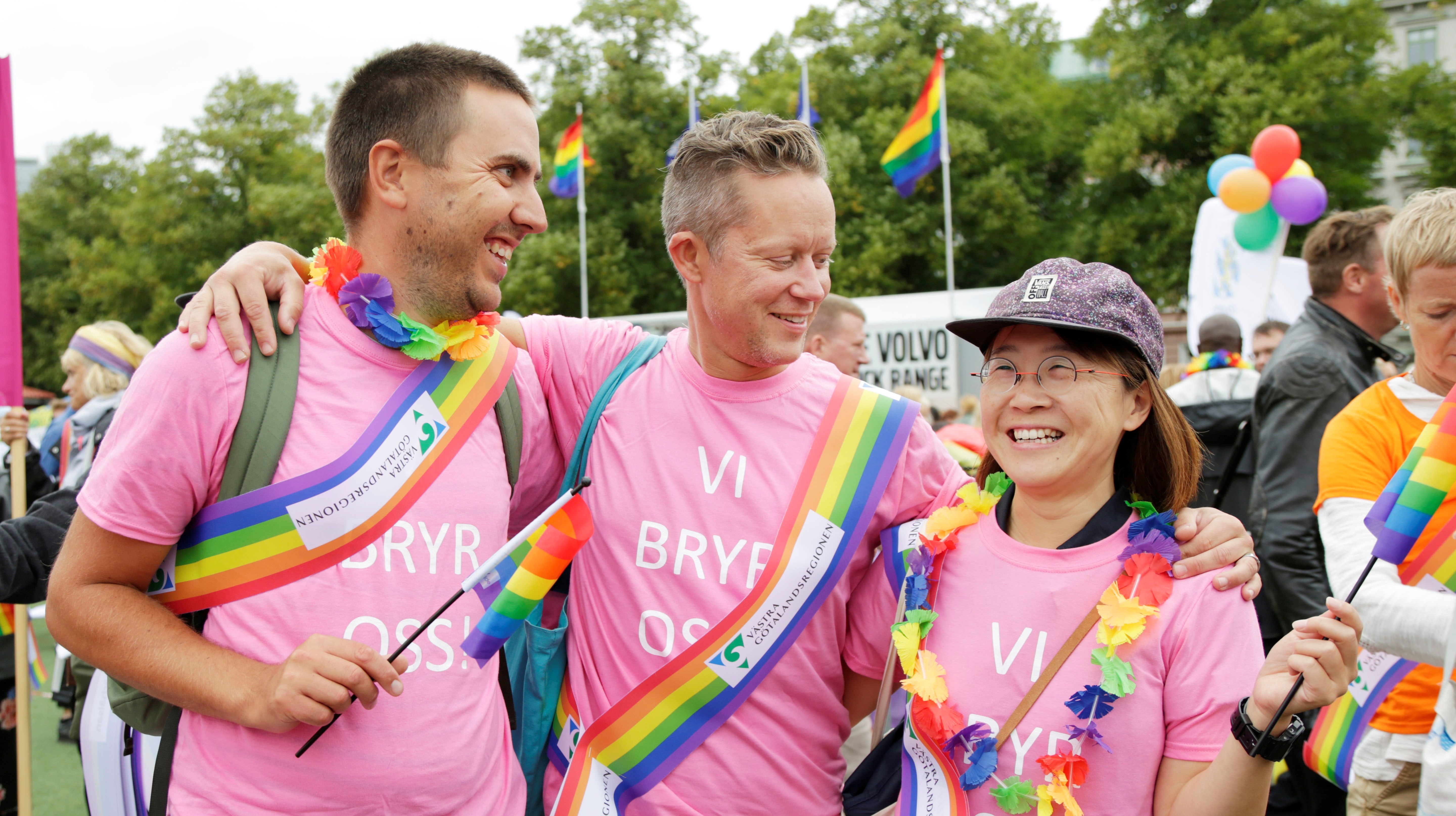 Tre personer i rosa tröjor på pridefestivalen